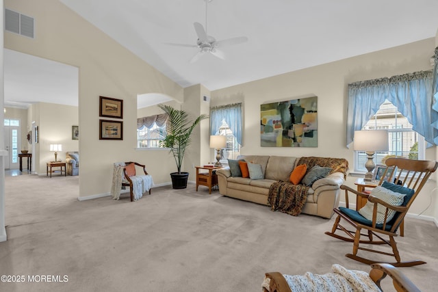 living room featuring carpet flooring, a ceiling fan, visible vents, and a healthy amount of sunlight