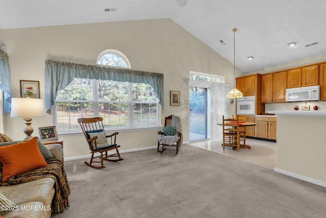 interior space featuring visible vents, baseboards, light carpet, and high vaulted ceiling