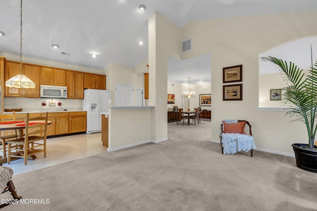 kitchen featuring an inviting chandelier, light carpet, white appliances, light countertops, and visible vents