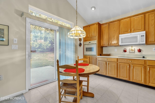 kitchen featuring brown cabinets, hanging light fixtures, white appliances, light countertops, and vaulted ceiling