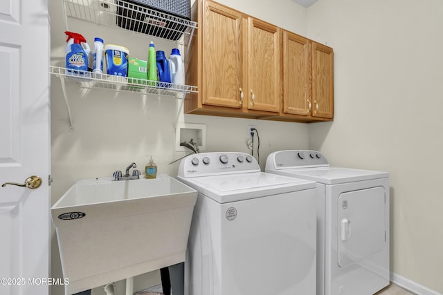 washroom featuring separate washer and dryer, a sink, and cabinet space