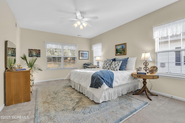 carpeted bedroom featuring baseboards and a ceiling fan