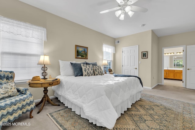 bedroom with baseboards, light carpet, ensuite bath, and visible vents