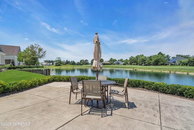 view of patio featuring a water view and outdoor dining space