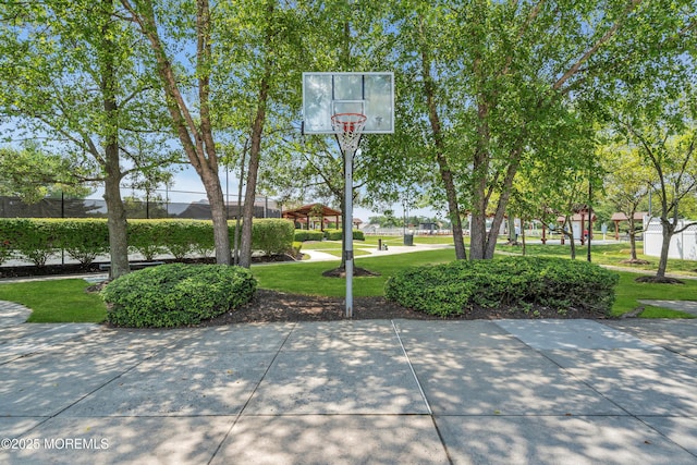 view of sport court featuring a lawn and basketball court