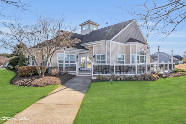 exterior space with french doors, roof with shingles, and a front lawn