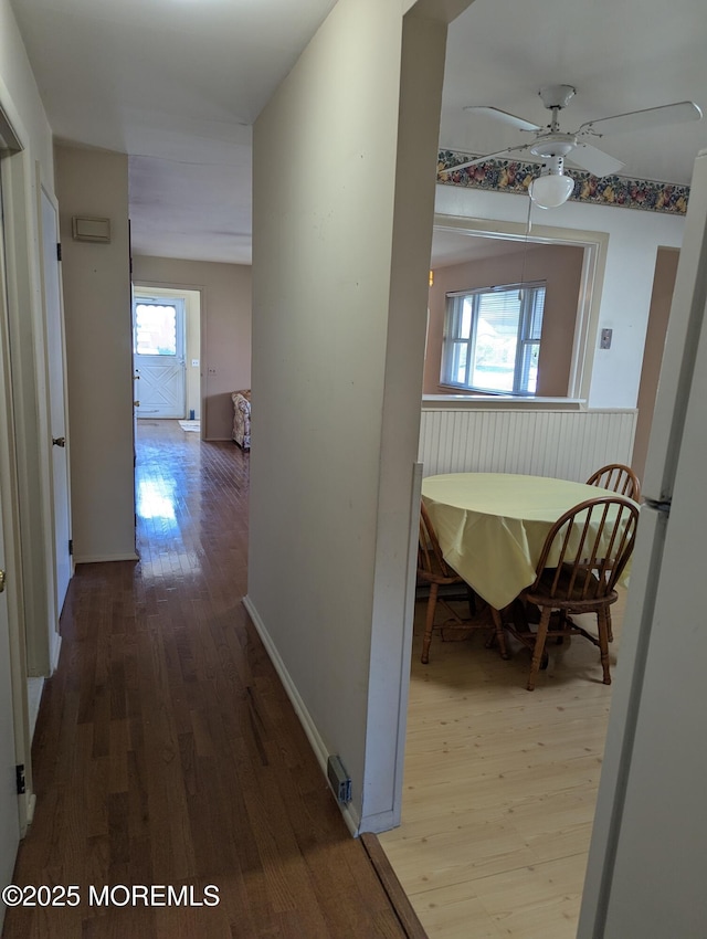 hallway with wood finished floors and baseboards