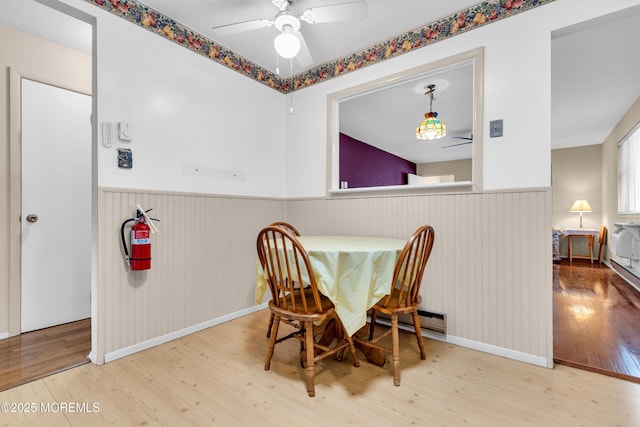 8A Lafayette Dr, Whiting, NJ 08759 - dining space featuring baseboard heating, baseboards, ceiling fan, a wainscoted wall, and wood finished floors