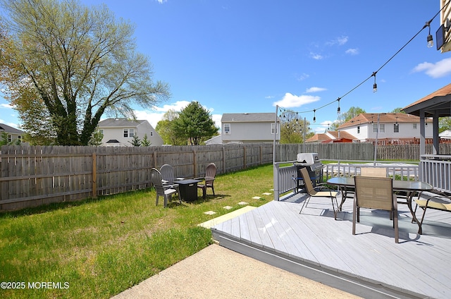 deck featuring a yard, a residential view, outdoor dining area, and a fenced backyard