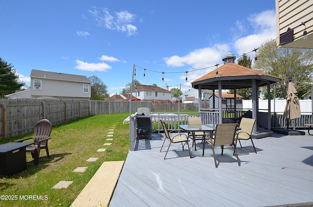 wooden deck with a lawn, a gazebo, a fenced backyard, outdoor dining space, and a grill