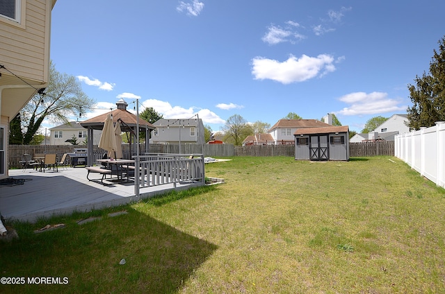 view of yard featuring a gazebo, a shed, a fenced backyard, an outbuilding, and a patio area