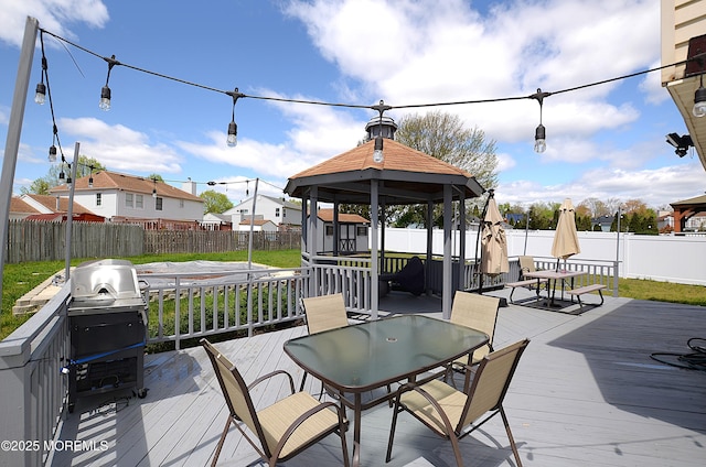 wooden deck featuring a gazebo, outdoor dining area, and a fenced backyard