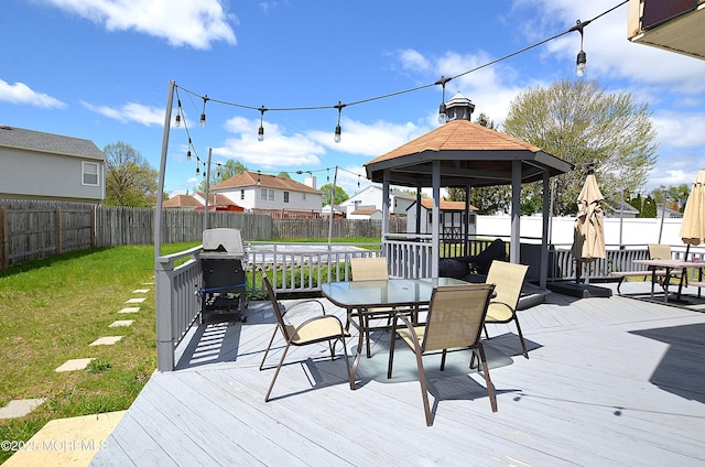 deck with a fenced backyard, outdoor dining space, and a gazebo