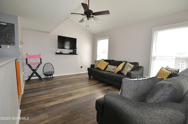 living area with baseboards, ceiling fan, wood finished floors, and vaulted ceiling