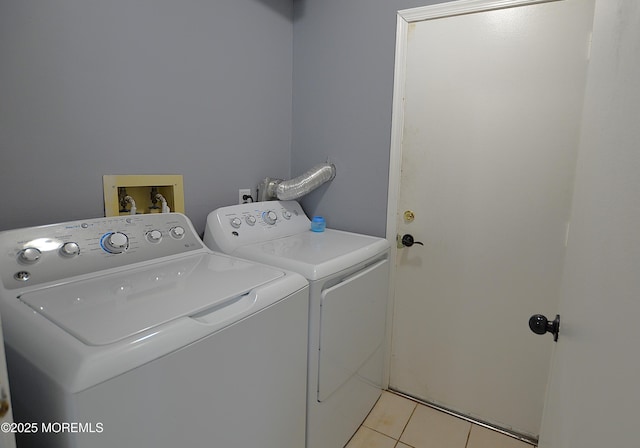 clothes washing area featuring laundry area, light tile patterned floors, and separate washer and dryer