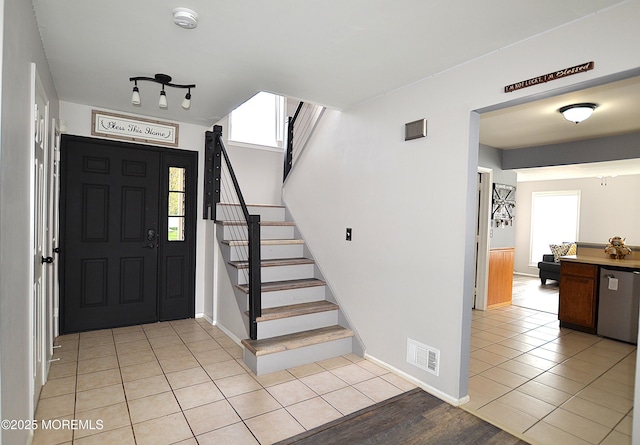 entrance foyer featuring stairway, light tile patterned floors, baseboards, and visible vents