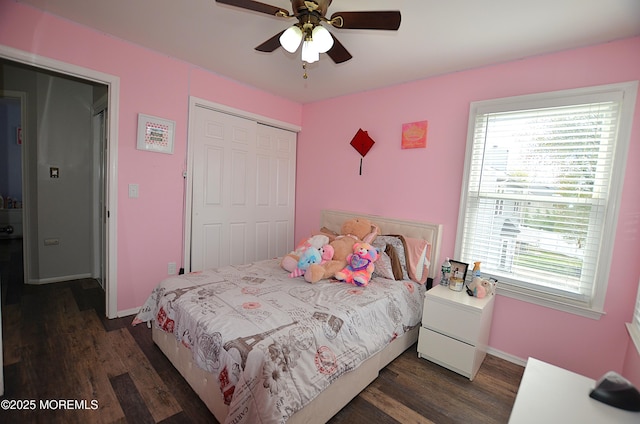 bedroom featuring a closet, dark wood-style flooring, baseboards, and multiple windows