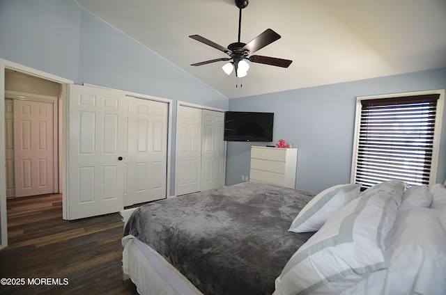 bedroom featuring a ceiling fan, high vaulted ceiling, multiple closets, and dark wood-style floors