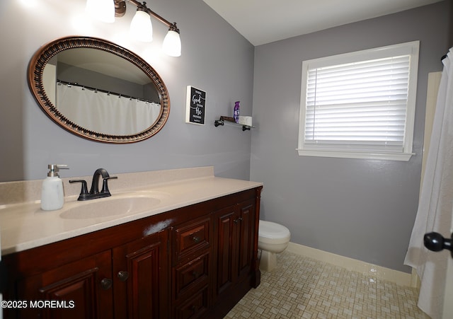 bathroom featuring vanity, baseboards, and toilet