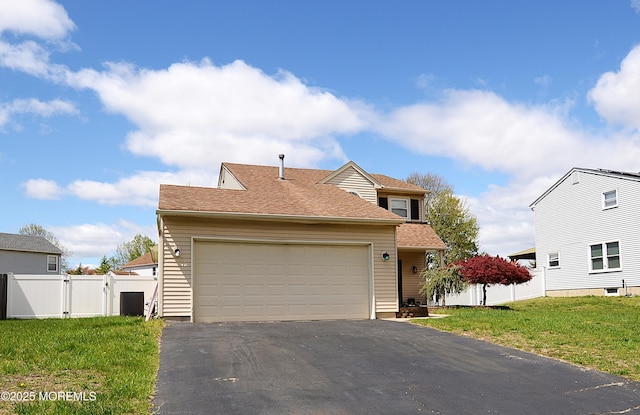 traditional home with fence, a front lawn, a garage, a gate, and driveway