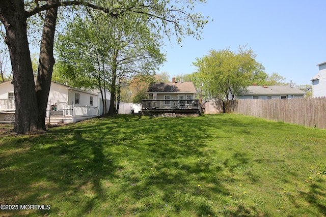 view of yard featuring a deck, an outbuilding, a shed, and a fenced backyard