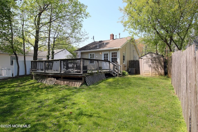 rear view of property with a wooden deck, a fenced backyard, cooling unit, a shed, and a chimney