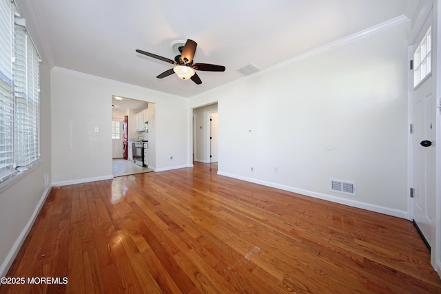 unfurnished living room featuring light wood finished floors, ceiling fan, crown molding, visible vents, and baseboards