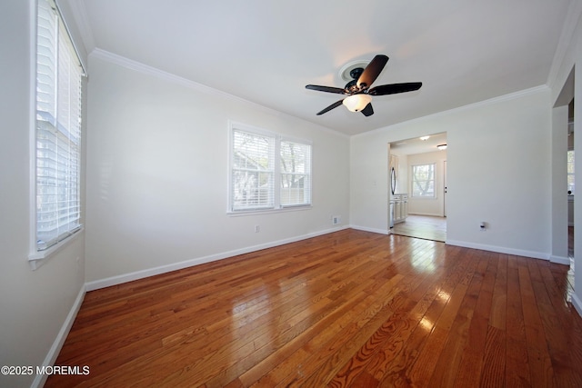 interior space featuring ceiling fan, hardwood / wood-style floors, ornamental molding, and baseboards