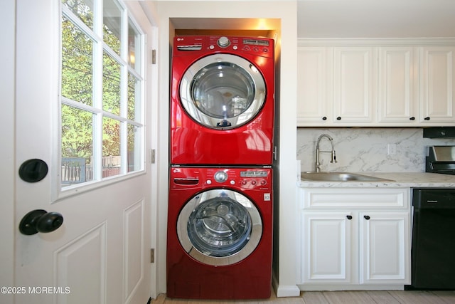 laundry room with stacked washing maching and dryer, laundry area, and a sink