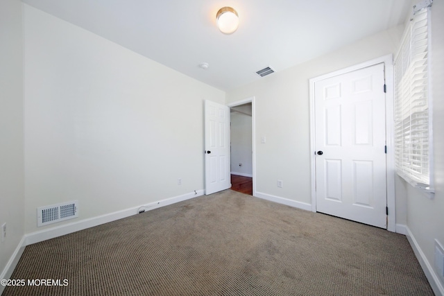 unfurnished bedroom with visible vents, carpet floors, and baseboards