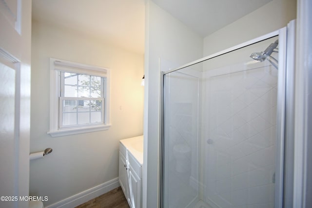 full bathroom with vanity, a shower stall, wood finished floors, and baseboards