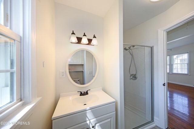 full bath with a walk in shower, wood finished floors, and vanity