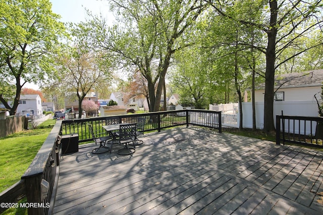 deck with a residential view, outdoor dining area, a yard, and fence