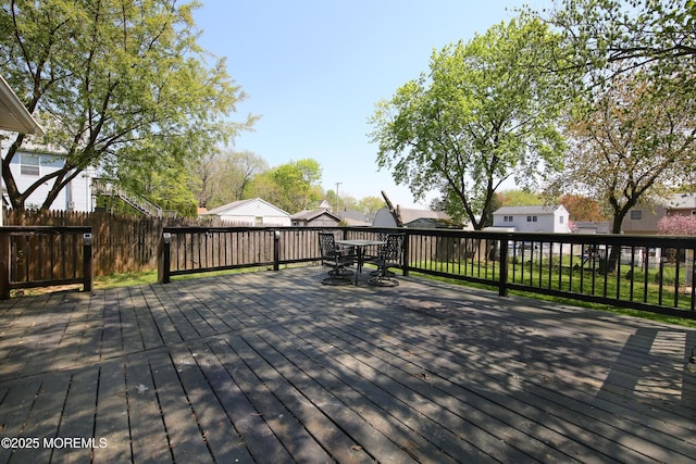 deck featuring fence, outdoor dining space, and a residential view