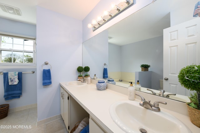 bathroom with double vanity, a sink, tile patterned floors, and visible vents