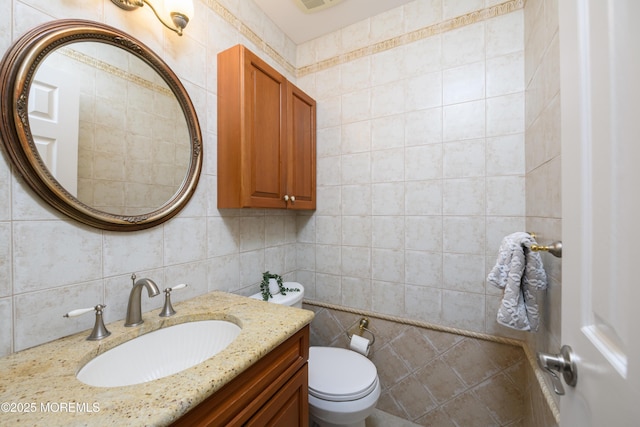 half bath with toilet, tile walls, backsplash, and vanity