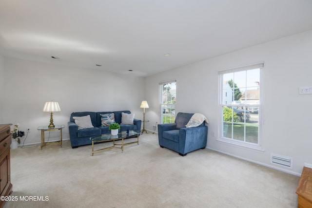 living room featuring visible vents, light carpet, and baseboards