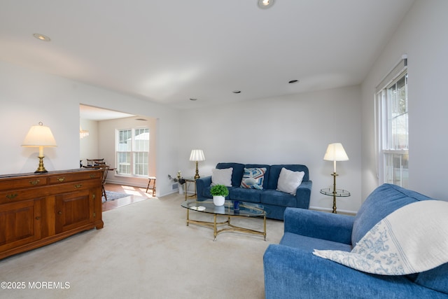 living area with baseboards, recessed lighting, light colored carpet, and plenty of natural light
