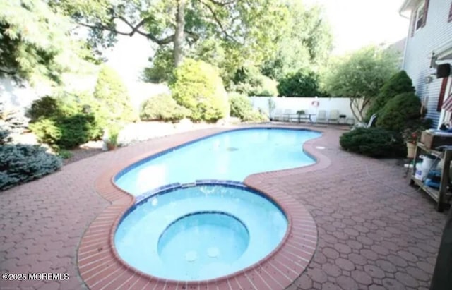 view of pool with a pool with connected hot tub