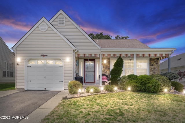 ranch-style house with aphalt driveway, stone siding, roof with shingles, a yard, and a garage