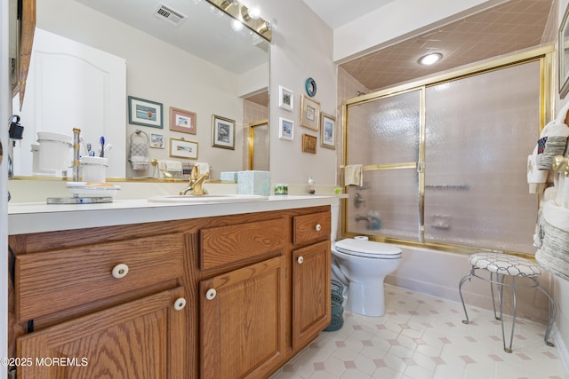 bathroom with tile patterned floors, enclosed tub / shower combo, toilet, vanity, and visible vents