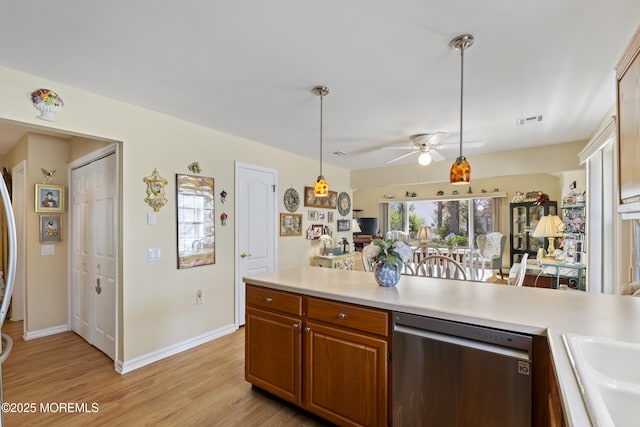 kitchen with a sink, ceiling fan, visible vents, light countertops, and stainless steel dishwasher