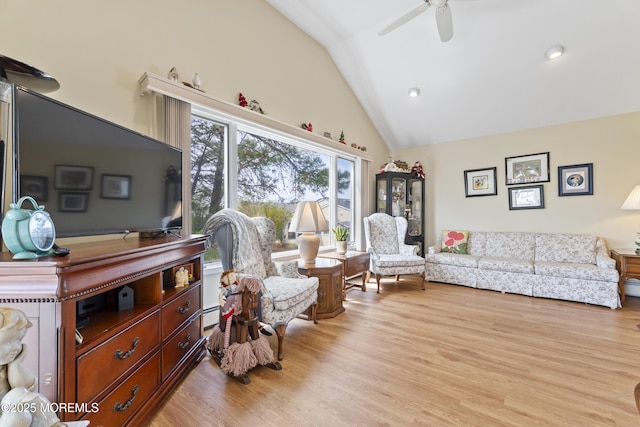 living area featuring light wood-type flooring, a ceiling fan, and high vaulted ceiling