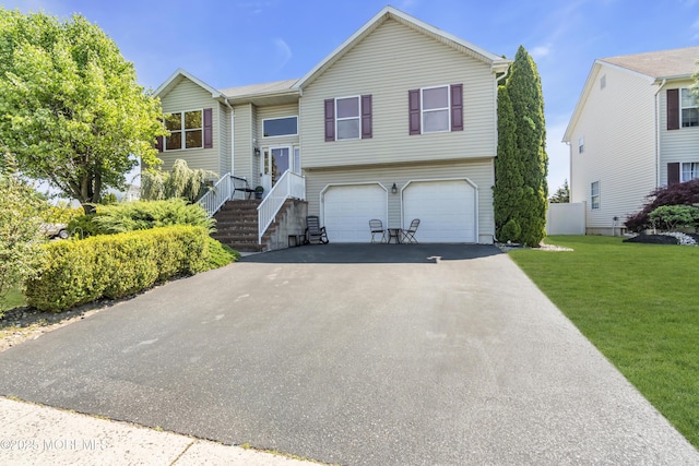 bi-level home with an attached garage, driveway, and a front yard