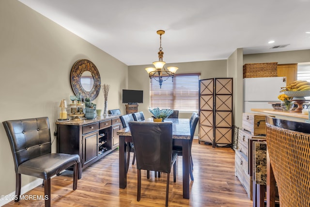 dining room featuring recessed lighting, a notable chandelier, visible vents, and light wood-style flooring