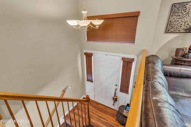 foyer entrance featuring stairs, wood finished floors, and a chandelier