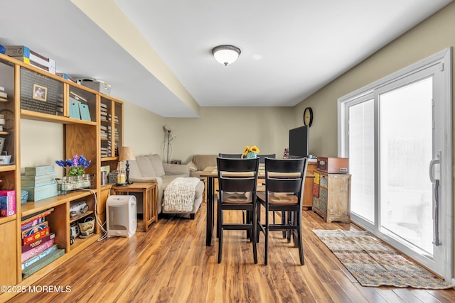 dining space featuring wood finished floors and a healthy amount of sunlight