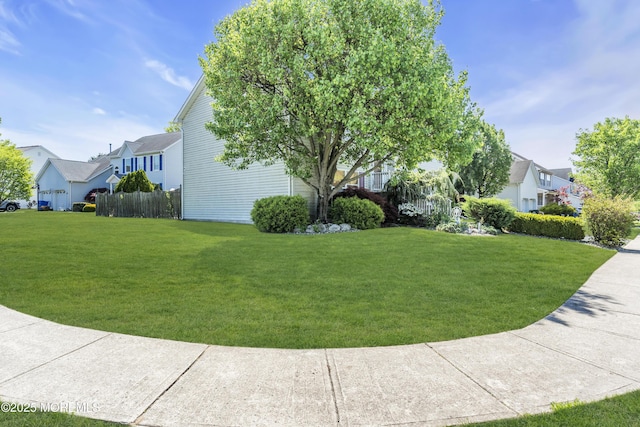 view of property exterior with fence, a yard, and a residential view