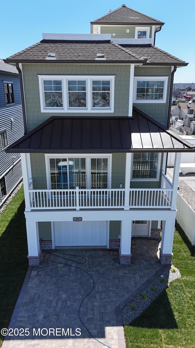 view of front of home featuring a shingled roof, metal roof, and a standing seam roof