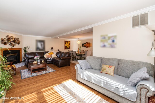 291 Marigold Ct, Toms River, NJ 08753 - living room with recessed lighting, wood finished floors, ornamental molding, a glass covered fireplace, and visible vents